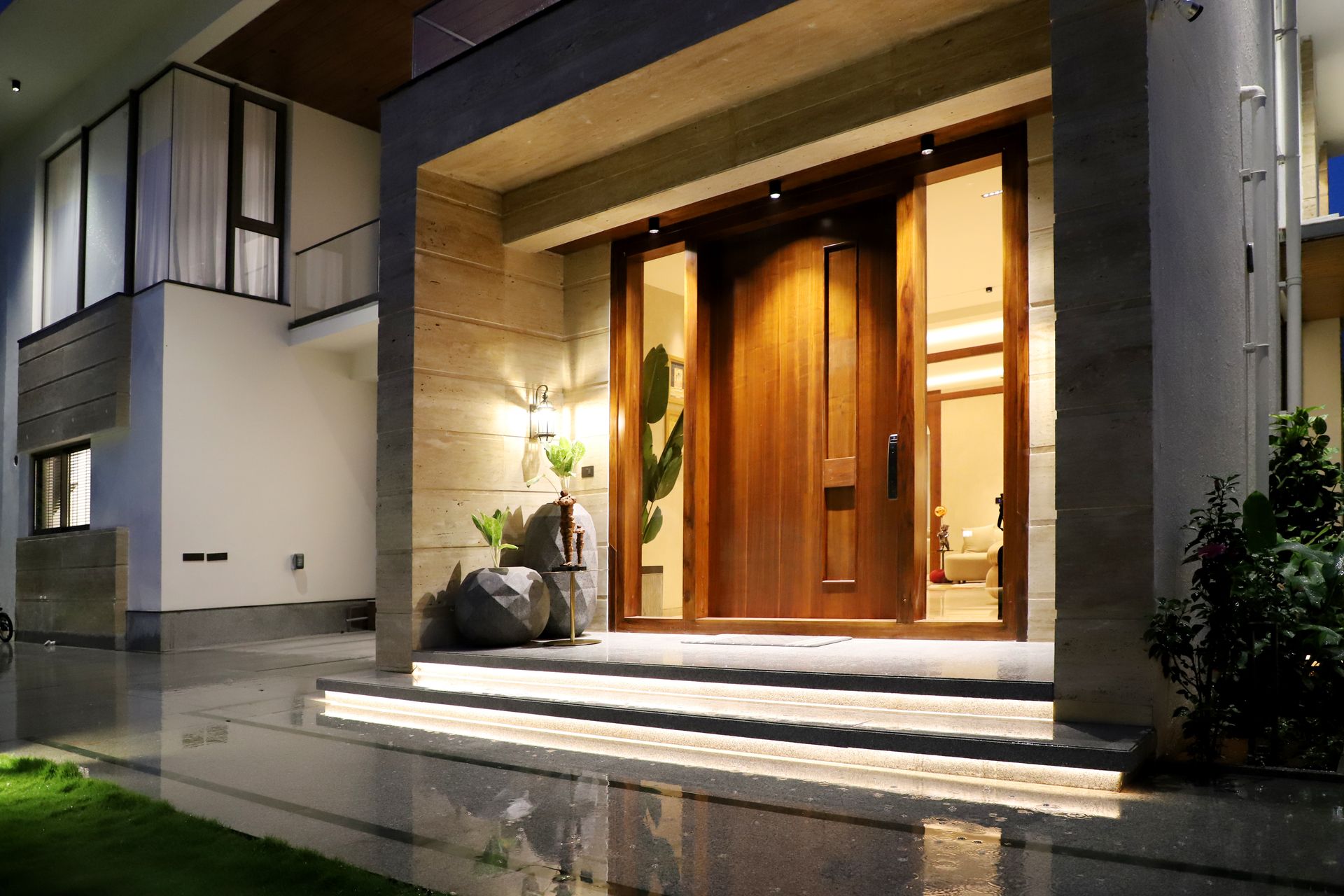 Entrée de maison moderne éclairée avec porte contemporaine sur mesure